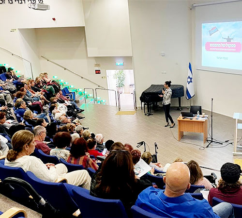 נעמה אביעד באודיטוריום מול קהל בסדנה "פסקול של מהפכות" בראשל"צ