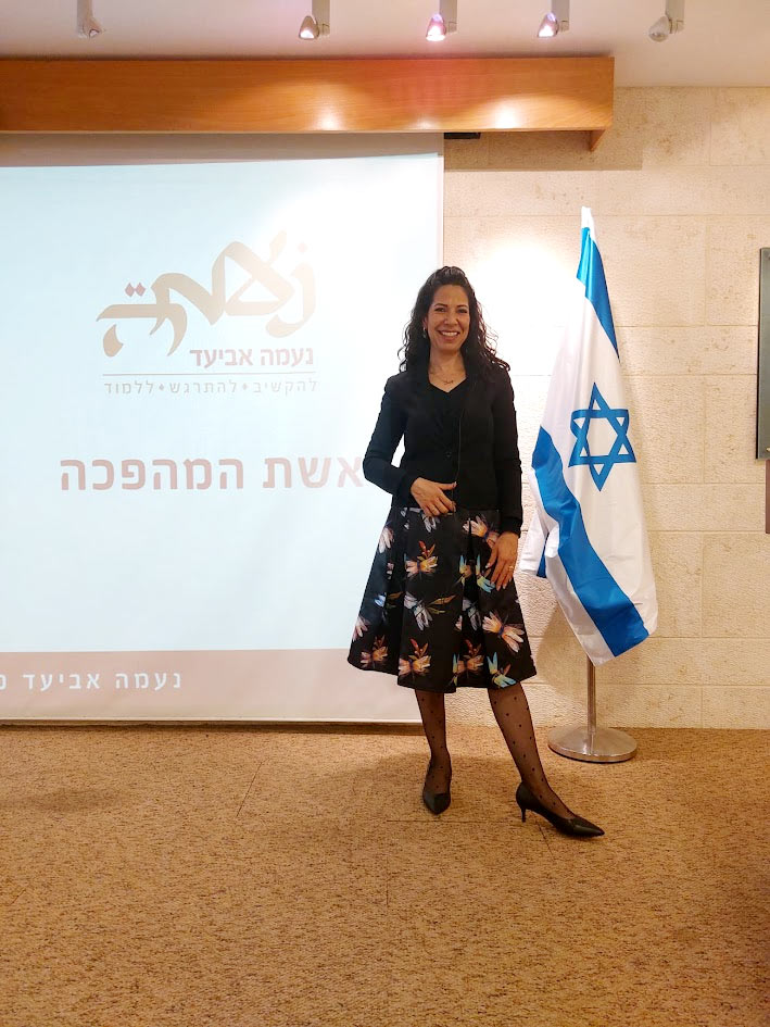 נעמה אביעד על במה בסדנת העצמה לנשים "אשת המהפכה" במשרד החוץ.